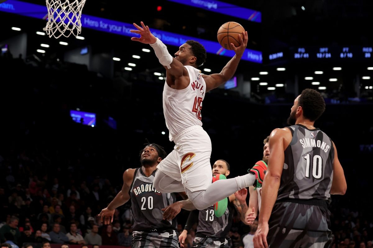 Dec 16, 2024; Brooklyn, New York, USA; Cleveland Cavaliers guard Donovan Mitchell (45) dunks against Brooklyn Nets center Day'Ron Sharpe (20) and guards Tyrese Martin (13) and Ben Simmons (10) during the second quarter at Barclays Center. Mandatory Credit: Brad Penner-Imagn Images
