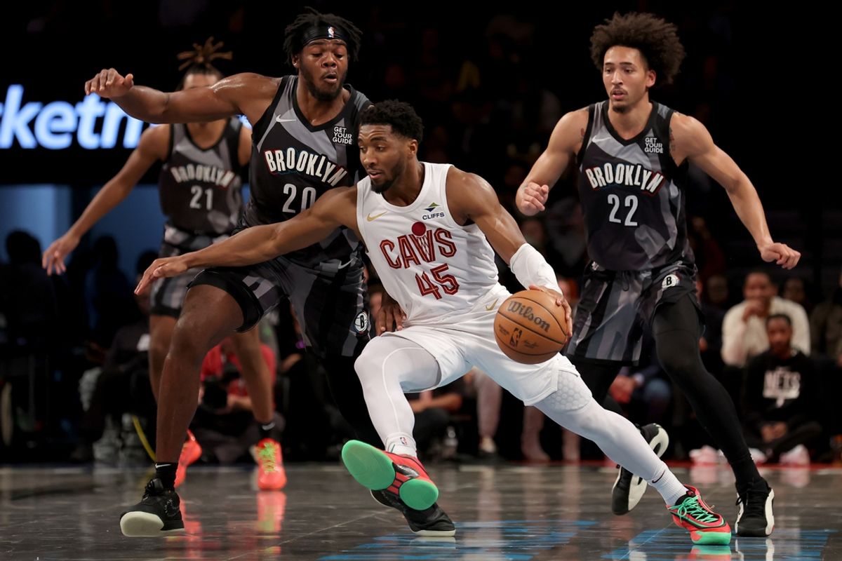 Dec 16, 2024; Brooklyn, New York, USA; Cleveland Cavaliers guard Donovan Mitchell (45) controls the ball against Brooklyn Nets center Day'Ron Sharpe (20) and forward Jalen Wilson (22) during the third quarter at Barclays Center. Mandatory Credit: Brad Penner-Imagn Images