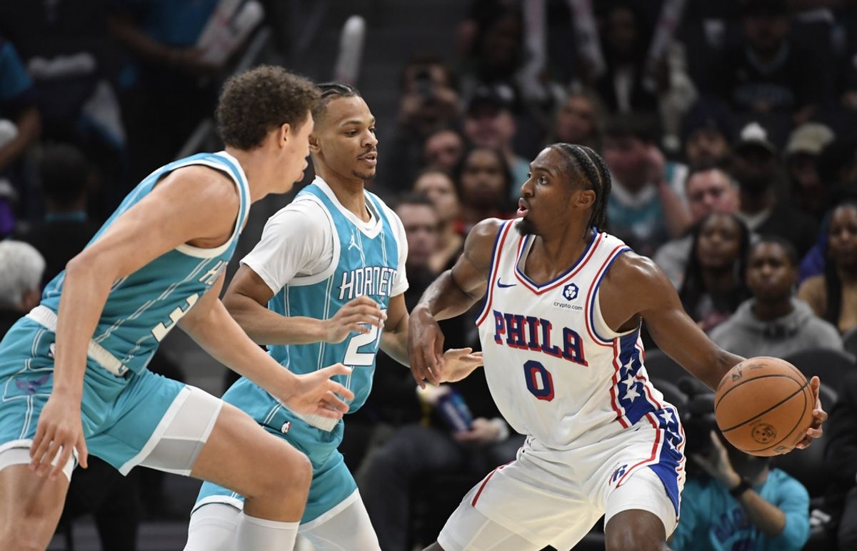 Dec 16, 2024; Charlotte, North Carolina, USA;  Philadelphia 76ers guard Tyrese Maxey (0) looks to pass through the defense of Charlotte Hornets guard Isaiah Wong (21) and forward Tidjane Salaun (31) during the second half at the Spectrum Center. Mandatory Credit: Sam Sharpe-Imagn Images