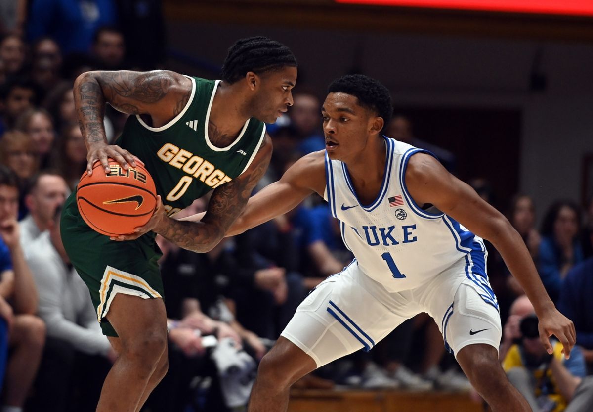 Dec 17, 2024; Durham, North Carolina, USA; George Mason Patriots guard KD Johnson (0) controls the ball in front of Duke Blue Devils guard Caleb Foster (1) during the first half at Cameron Indoor Stadium. Mandatory Credit: Rob Kinnan-Imagn Images