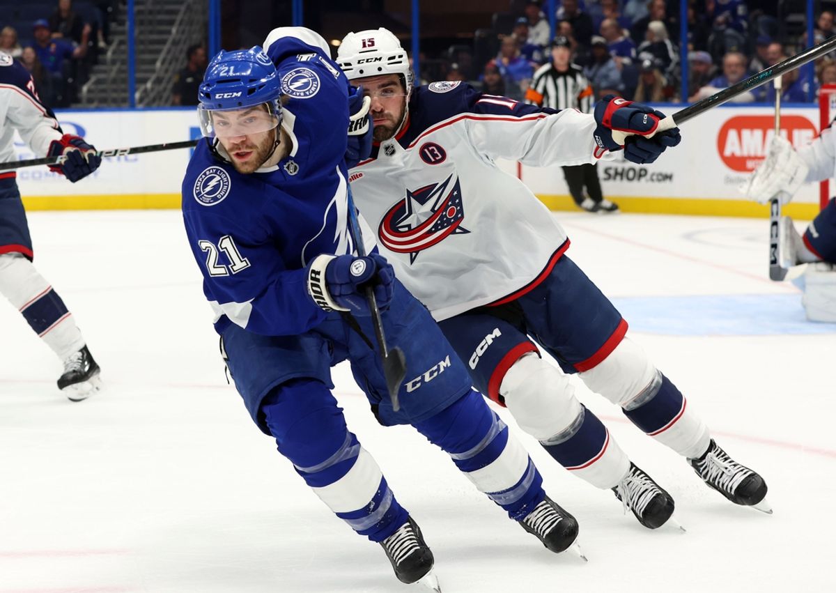 Dec 17, 2024; Tampa, Florida, USA; Tampa Bay Lightning center Brayden Point (21) and Columbus Blue Jackets defenseman Dante Fabbro (15) skate to control the puck during the first period at Amalie Arena. Mandatory Credit: Kim Klement Neitzel-Imagn Images