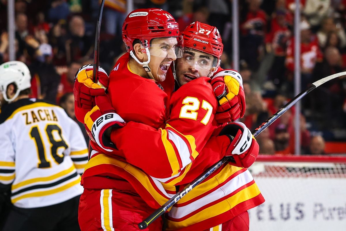 Dec 17, 2024; Calgary, Alberta, CAN; Calgary Flames right wing Matt Coronato (27) celebrates his goal with center Mikael Backlund (11) during the second period against the Boston Bruins at Scotiabank Saddledome. Mandatory Credit: Sergei Belski-Imagn Images