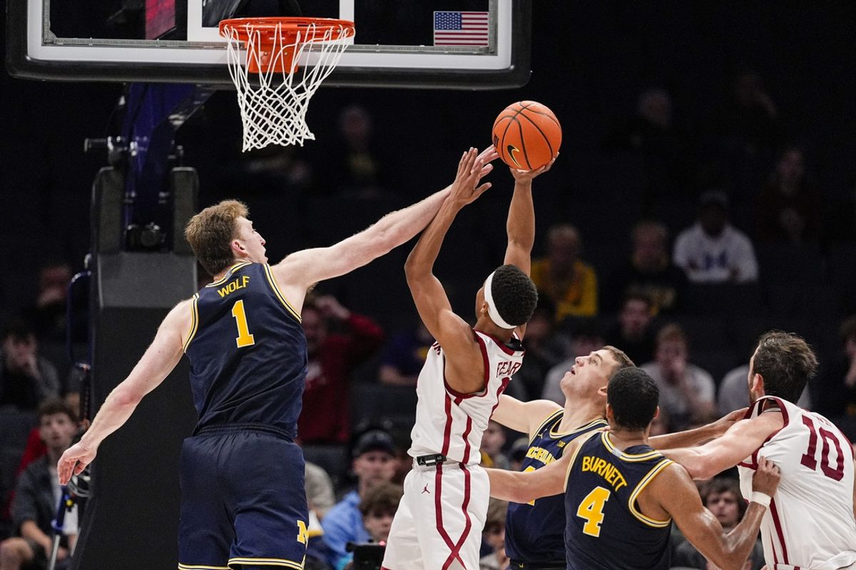 Dec 18, 2024; Charlotte, North Carolina, USA; Michigan Wolverines center Danny Wolf (1) tries to block a shot by Oklahoma Sooners guard Jeremiah Fears (0) during the second half at Spectrum Center. Mandatory Credit: Jim Dedmon-Imagn Images