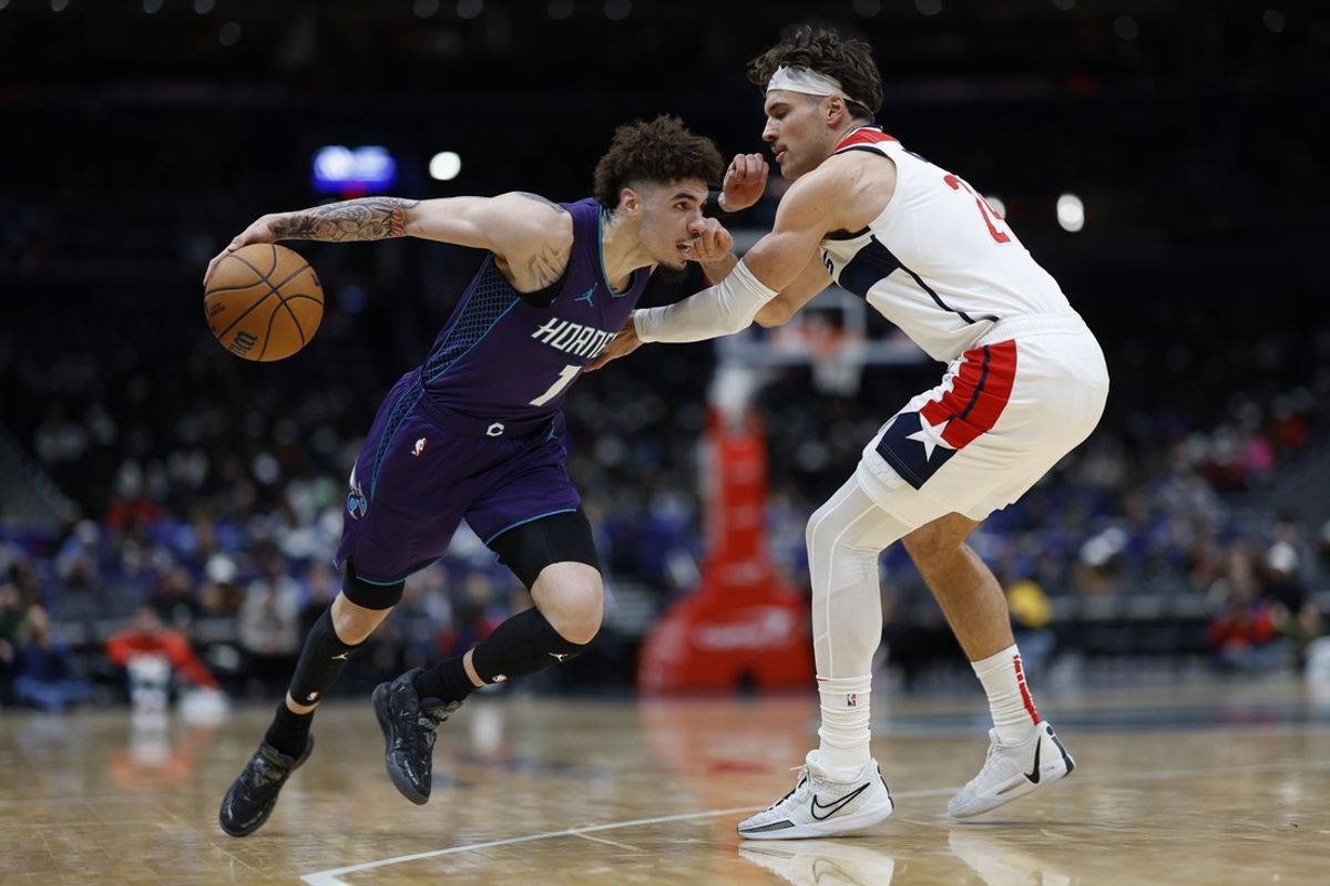 Dec 19, 2024; Washington, District of Columbia, USA; Charlotte Hornets guard LaMelo Ball (1) drives to the basket as Washington Wizards forward Corey Kispert (24) defends in the second quarter at Capital One Arena. Mandatory Credit: Geoff Burke-Imagn Images