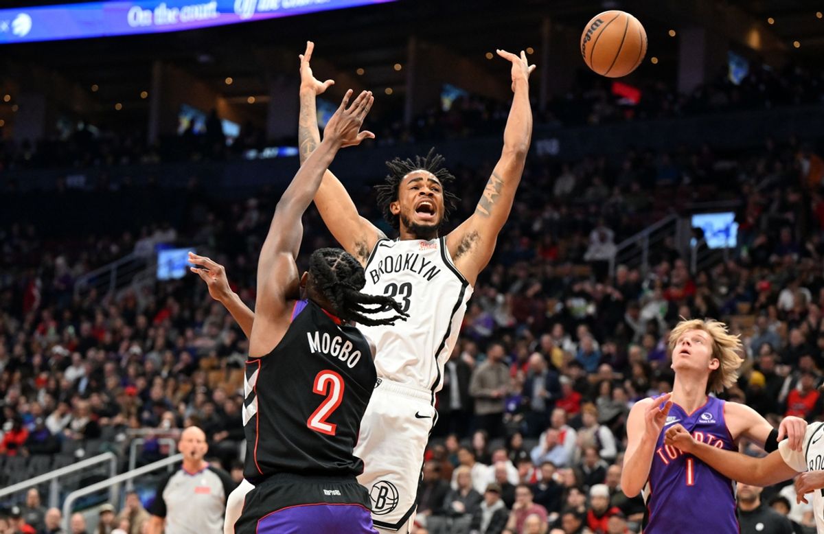 Dec 19, 2024; Toronto, Ontario, CAN;  Brooklyn Nets center Nic Claxton (33) loses control of the ball against Toronto Raptors forward Jonathan Mogbo (2) in the first quarter at Scotiabank Arena. Mandatory Credit: Dan Hamilton-Imagn Images