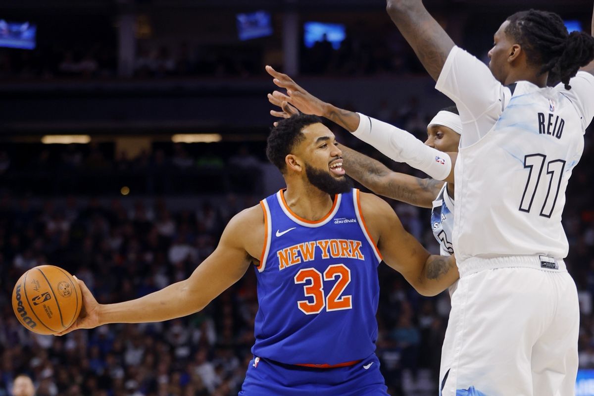 Dec 19, 2024; Minneapolis, Minnesota, USA; New York Knicks forward Karl-Anthony Towns (32) looks to pass as Minnesota Timberwolves forward Jaden McDaniels (3) and center Naz Reid (11) defend him in the first quarter at Target Center. Mandatory Credit: Bruce Kluckhohn-Imagn Images