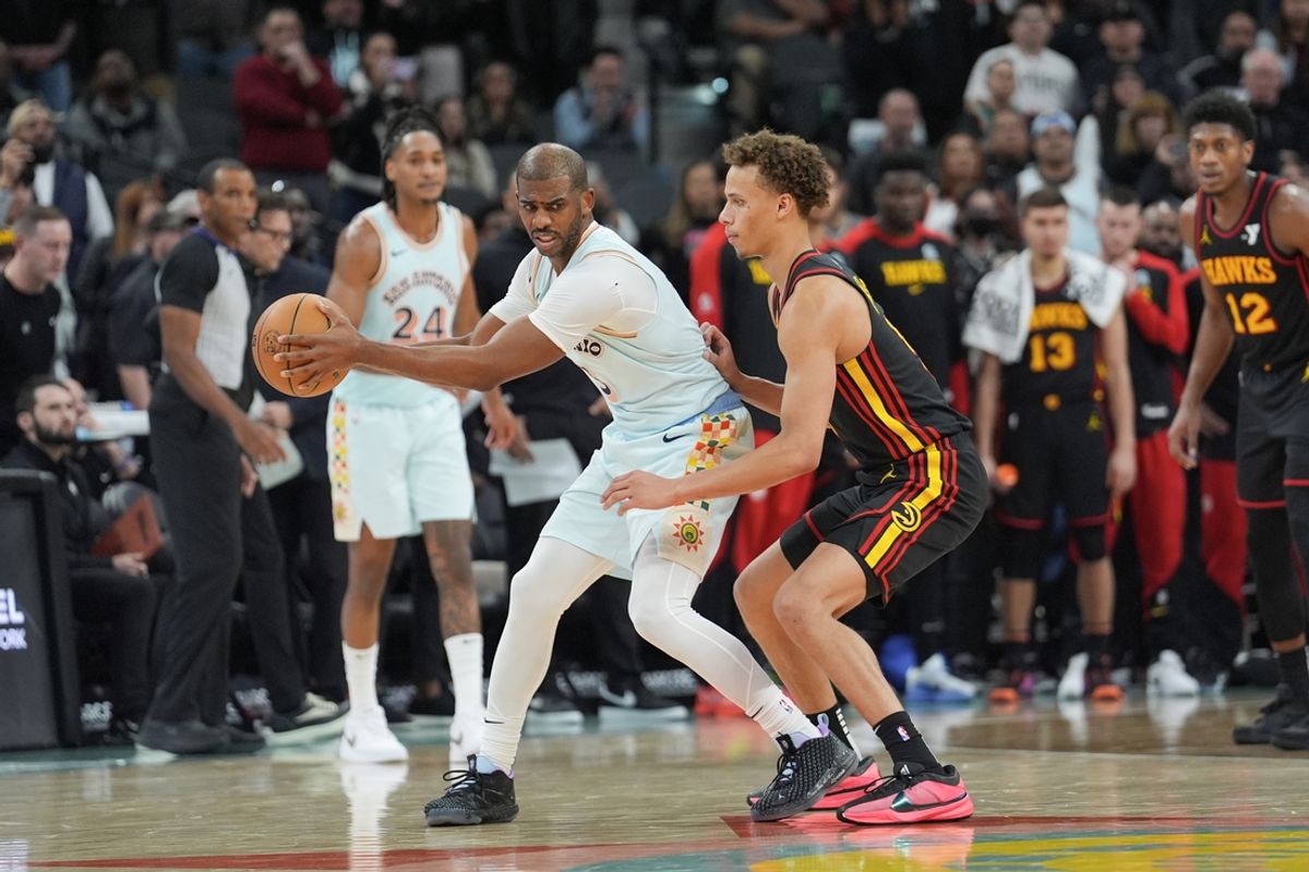 Dec 19, 2024; San Antonio, Texas, USA;  San Antonio Spurs guard Chris Paul (3) holds the ball away from Atlanta Hawks guard Dyson Daniels (5) in overtime at Frost Bank Center. Mandatory Credit: Daniel Dunn-Imagn Images