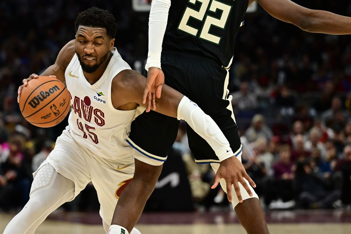 Dec 20, 2024; Cleveland, Ohio, USA; Cleveland Cavaliers guard Donovan Mitchell (45) drives to the basket against Milwaukee Bucks forward Khris Middleton (22) during the second half at Rocket Mortgage FieldHouse. Mandatory Credit: Ken Blaze-Imagn Images