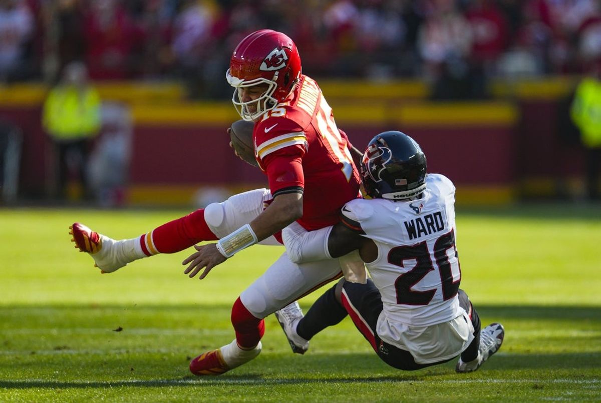 Dec 21, 2024; Kansas City, Missouri, USA; Kansas City Chiefs quarterback Patrick Mahomes (15) is tackled by Houston Texans safety Jimmie Ward (20) during the first half at GEHA Field at Arrowhead Stadium. Mandatory Credit: Jay Biggerstaff-Imagn Images