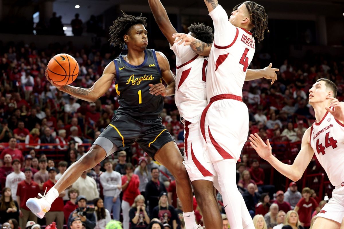 Dec 21, 2024; Fayetteville, Arkansas, USA; North Carolina A&T Aggies guard Ryan Forrest (1) passes in the first half as Arkansas Razorbacks forward Trevon Brazile (4) defends at Bud Walton Arena. Mandatory Credit: Nelson Chenault-Imagn Images