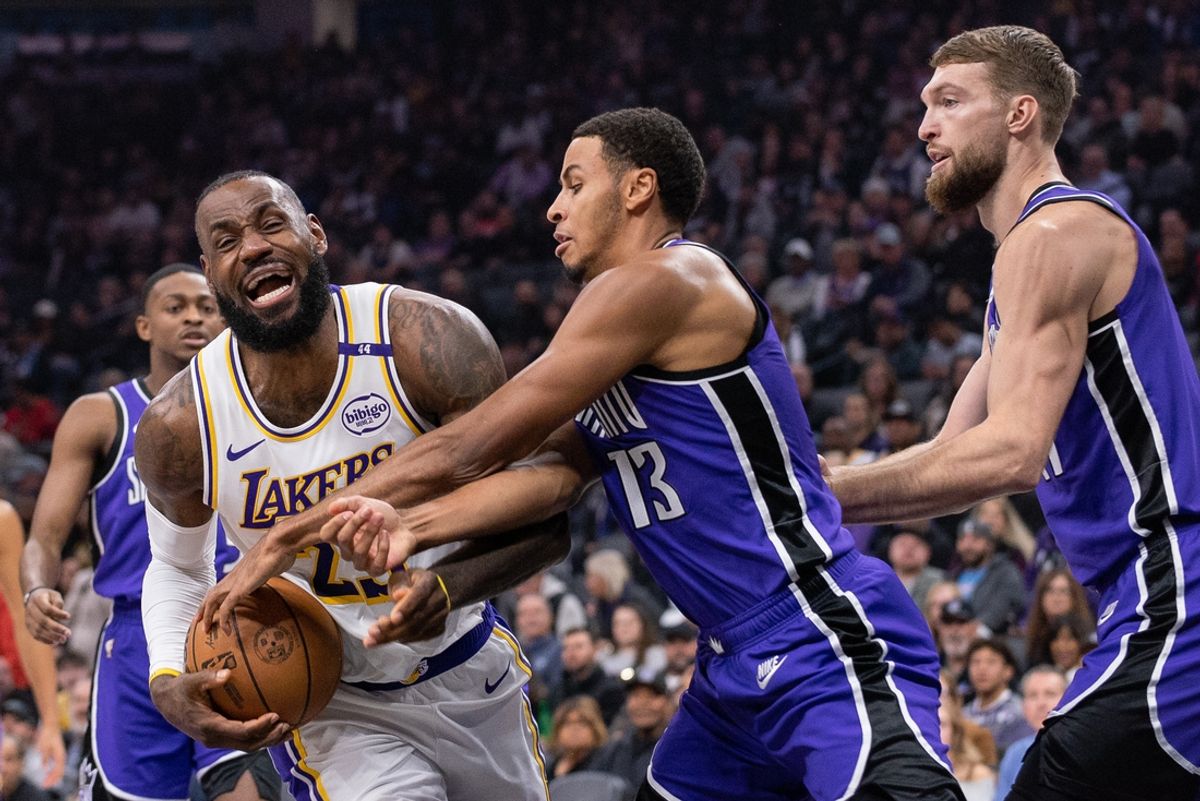 Dec 21, 2024; Sacramento, California, USA; Los Angeles Lakers forward LeBron James (23) and Sacramento Kings forward Keegan Murray (13) fight for possession of the ball during the first quarter at Golden 1 Center. Mandatory Credit: Ed Szczepanski-Imagn Images
