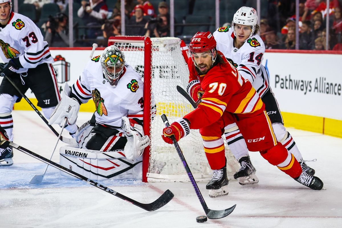 Dec 21, 2024; Calgary, Alberta, CAN; Calgary Flames left wing Ryan Lomberg (70) passes the puck against the Chicago Blackhawks during the third period at Scotiabank Saddledome. Mandatory Credit: Sergei Belski-Imagn Images