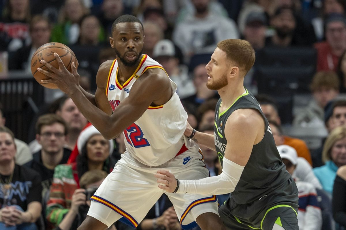 Dec 21, 2024; Minneapolis, Minnesota, USA; Golden State Warriors forward Andrew Wiggins (22) backs towards the basket as Minnesota Timberwolves guard Donte DiVincenzo (0) plays defense in the first half at Target Center. Mandatory Credit: Jesse Johnson-Imagn Images