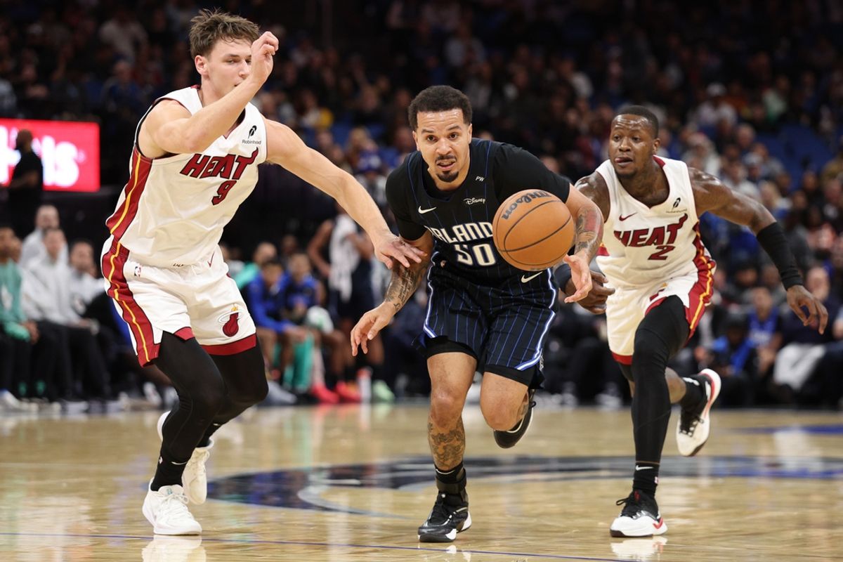 Dec 21, 2024; Orlando, Florida, USA; Orlando Magic guard Cole Anthony (50) controls a loose ball from Miami Heat guard Pelle Larsson (9) and guard Terry Rozier (2) in the third quarter at Kia Center. Mandatory Credit: Nathan Ray Seebeck-Imagn Images