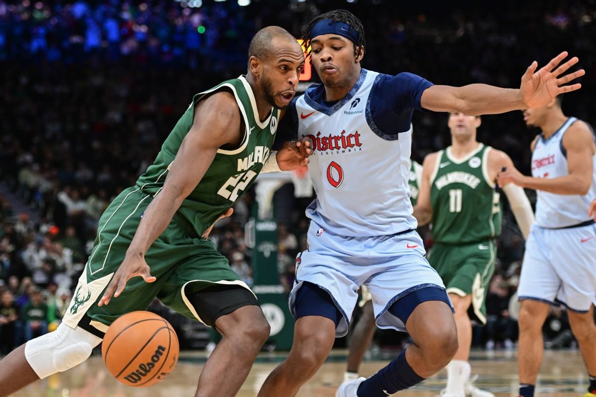Dec 21, 2024; Milwaukee, Wisconsin, USA;  Milwaukee Bucks forward Khris Middleton (22) drives to the basket against Washington Wizards forward Bilal Coulibaly (0) in the second quarter at Fiserv Forum. Mandatory Credit: Benny Sieu-Imagn Images