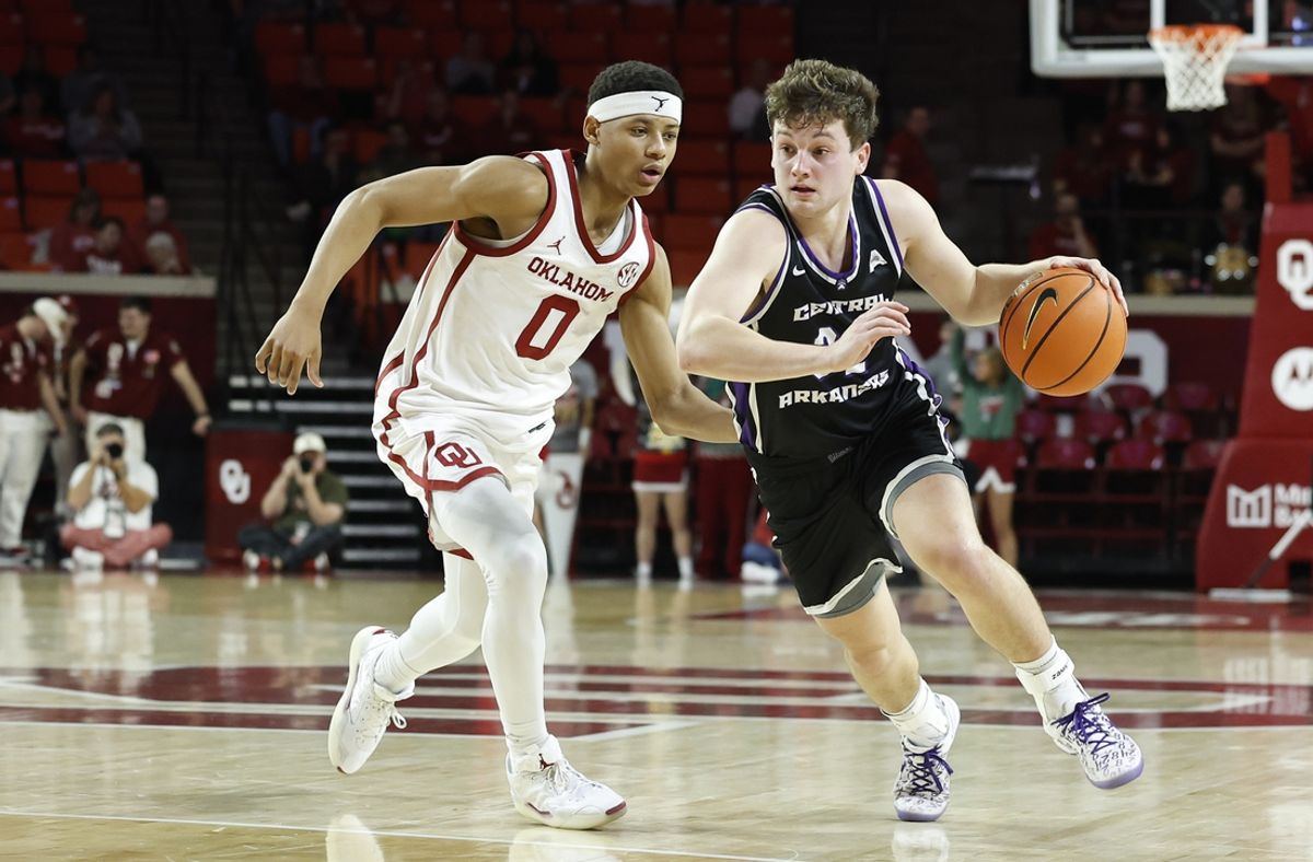 Dec 22, 2024; Norman, Oklahoma, USA; Central Arkansas Bears guard Layne Taylor (32) drives around Oklahoma Sooners guard Jeremiah Fears (0) during the first half at Lloyd Noble Center. Mandatory Credit: Alonzo Adams-Imagn Images