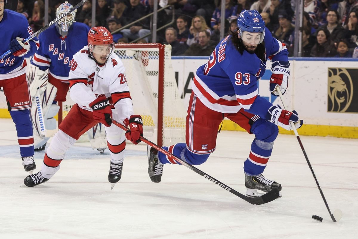Dec 22, 2024; New York, New York, USA;  Carolina Hurricanes center Sebastian Aho (20) and New York Rangers center Mika Zibanejad (93) chase the puck in the second period at Madison Square Garden. Mandatory Credit: Wendell Cruz-Imagn Images