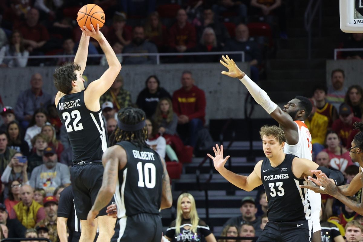 Dec 22, 2024; Ames, Iowa, USA; Iowa State Cyclones forward Milan Momcilovic (22) shoots over Morgan State Bears guard Pierce Shirk (22) during the second half at James H. Hilton Coliseum. Mandatory Credit: Reese Strickland-Imagn Images