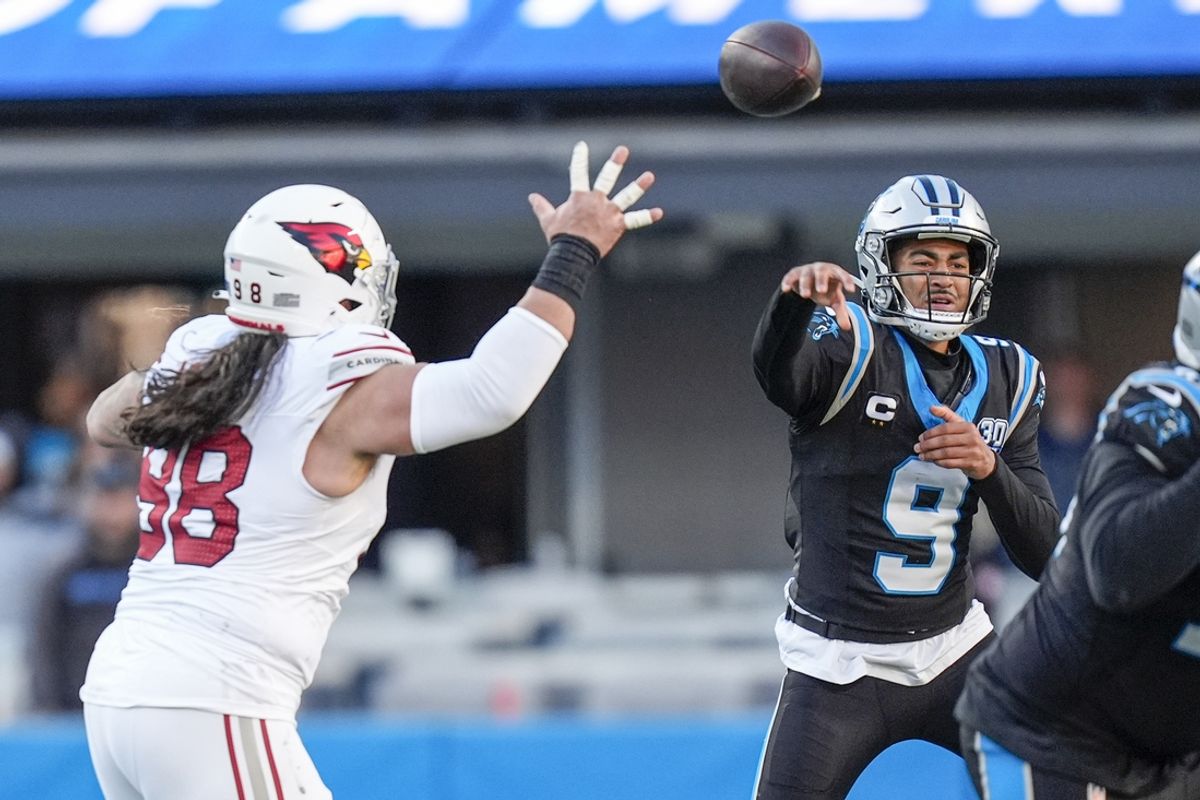 Dec 22, 2024; Charlotte, North Carolina, USA;  Carolina Panthers quarterback Bryce Young (9) throws under pressure from Arizona Cardinals defensive tackle Roy Lopez (98) during the second half at Bank of America Stadium. Mandatory Credit: Jim Dedmon-Imagn Images