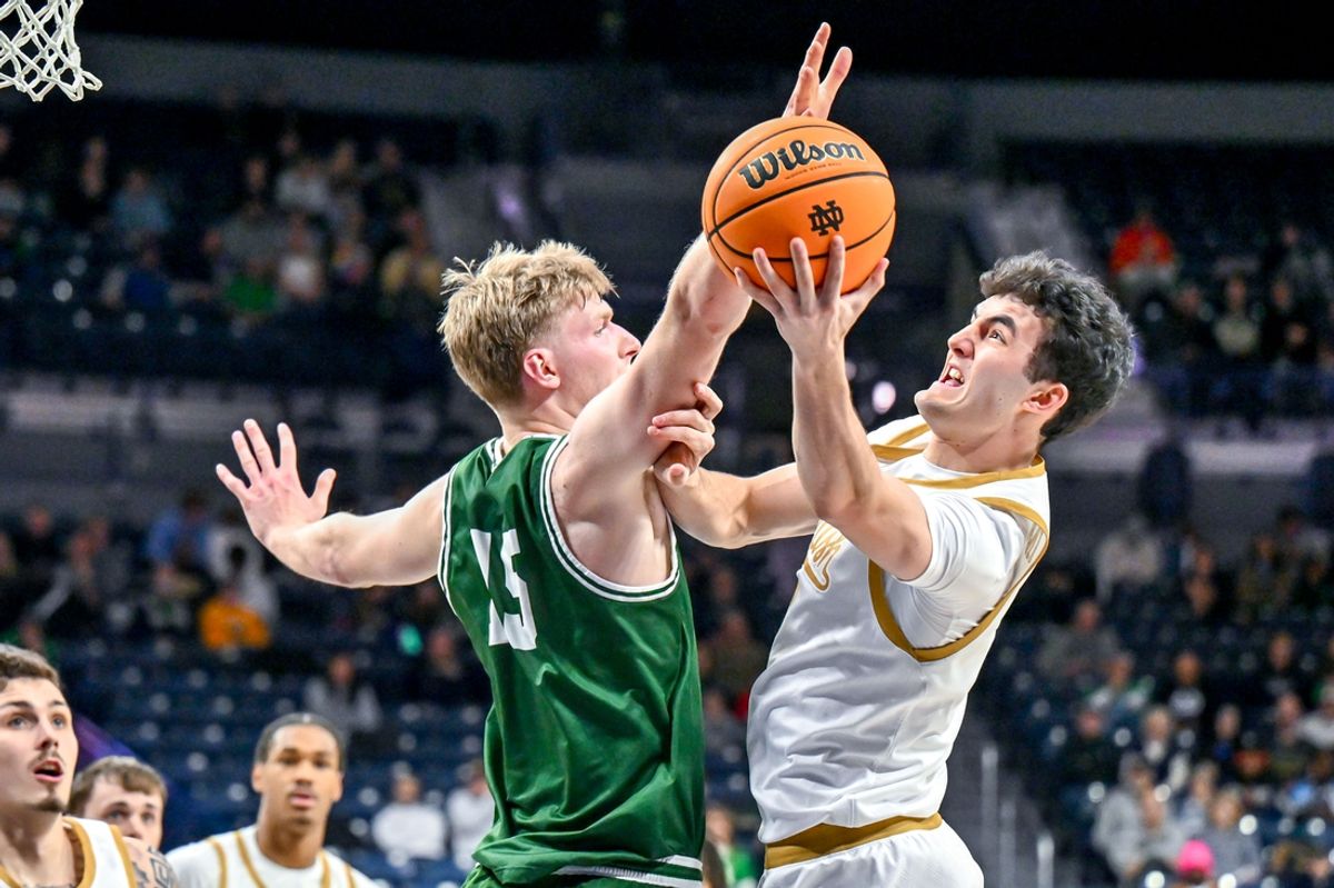 Dec 22, 2024; South Bend, Indiana, USA; Notre Dame Fighting Irish guard Logan Imes (2) goes up for a shot as Le Moyne Dolphins forward Nate Fouts (15) defends in the first half at the Purcell Pavilion. Mandatory Credit: Matt Cashore-Imagn Images