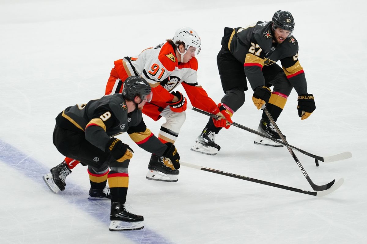 Dec 23, 2024; Las Vegas, Nevada, USA; Anaheim Ducks center Leo Carlsson (91) skates between Vegas Golden Knights defenseman Shea Theodore (27) and Vegas Golden Knights center Jack Eichel (9) during the second period at T-Mobile Arena. Mandatory Credit: Stephen R. Sylvanie-Imagn Images