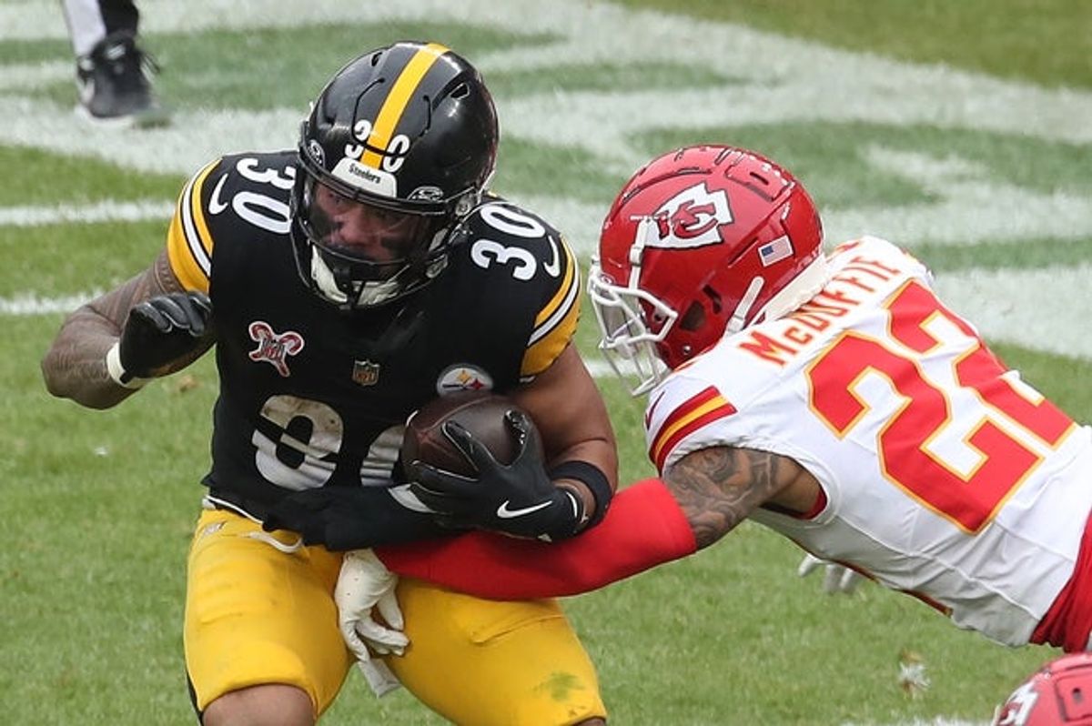 Dec 25, 2024; Pittsburgh, Pennsylvania, USA;  Pittsburgh Steelers running back Jaylen Warren (30 carries the ball against Kansas City Chiefs cornerback Trent McDuffie (22) during the third quarter at Acrisure Stadium. Mandatory Credit: Charles LeClaire-Imagn Images