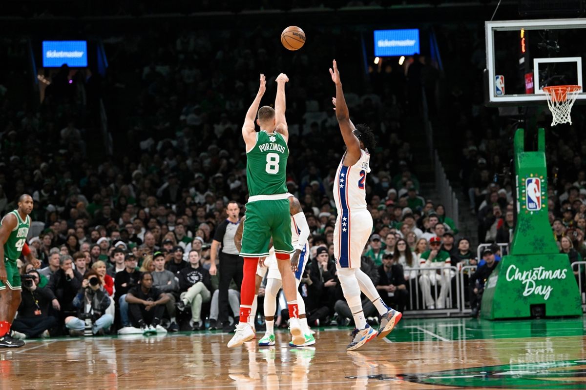 Dec 25, 2024; Boston, Massachusetts, USA; Boston Celtics center Kristaps Porzingis (8) shoots the ball against Philadelphia 76ers center Joel Embiid (21) during the first half at TD Garden. Mandatory Credit: Eric Canha-Imagn Images