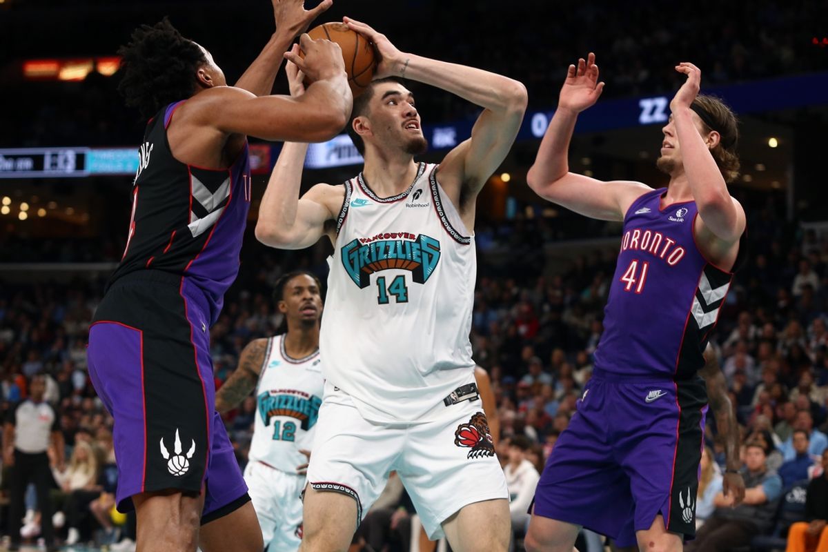 Dec 26, 2024; Memphis, Tennessee, USA; Memphis Grizzlies center Zach Edey (14) shoots as Toronto Raptors forward Scottie Barnes (4) and forward Kelly Olynyk (41) defends during the second quarter at FedExForum. Mandatory Credit: Petre Thomas-Imagn Images