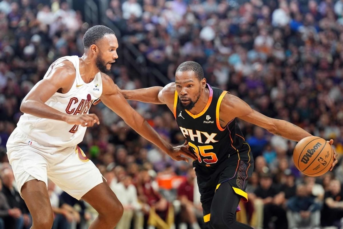 Apr 3, 2024; Phoenix, Arizona, USA; Phoenix Suns forward Kevin Durant (35) dribble against Cleveland Cavaliers forward Evan Mobley (4) during the first half at Footprint Center.