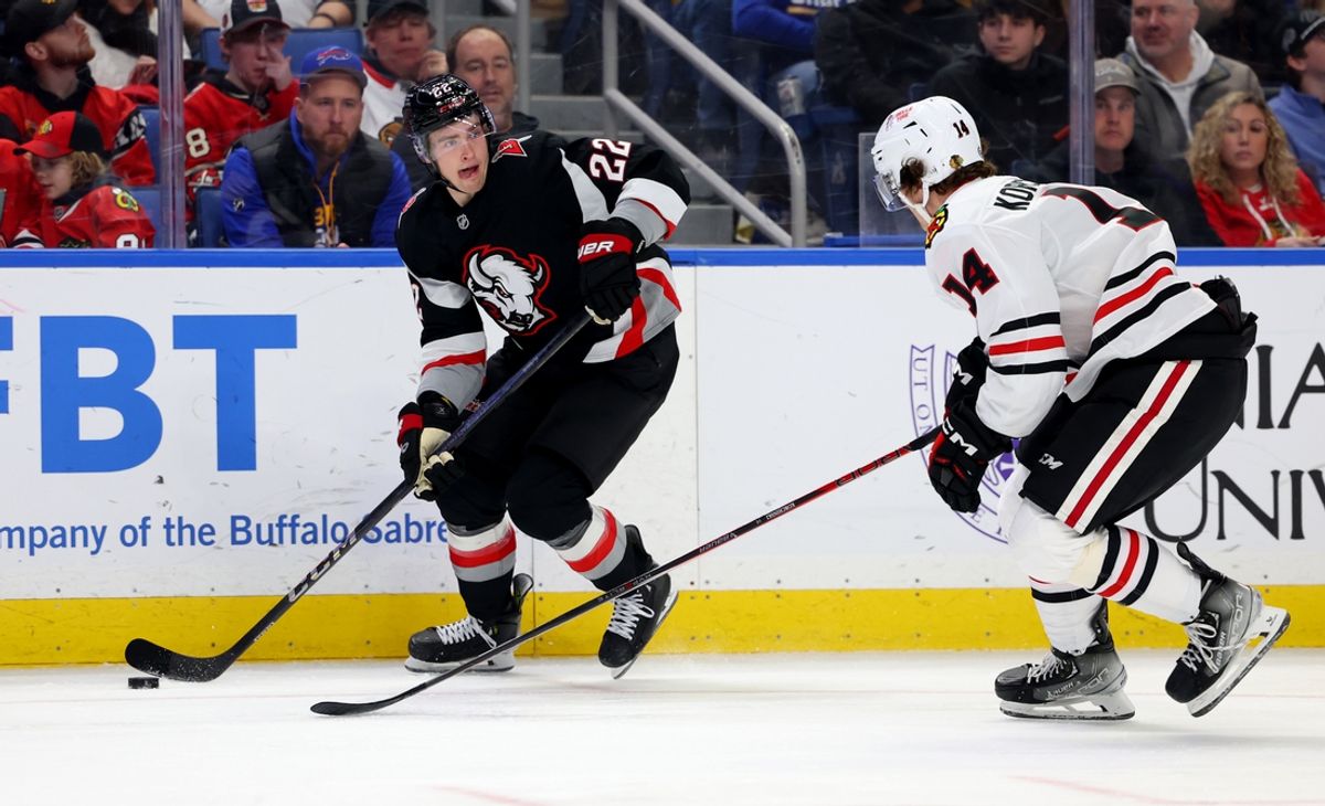 Dec 27, 2024; Buffalo, New York, USA;  Buffalo Sabres right wing Jack Quinn (22) skates with the puck as Chicago Blackhawks defenseman Kevin Korchinski (14) defends during the second period at KeyBank Center. Mandatory Credit: Timothy T. Ludwig-Imagn Images