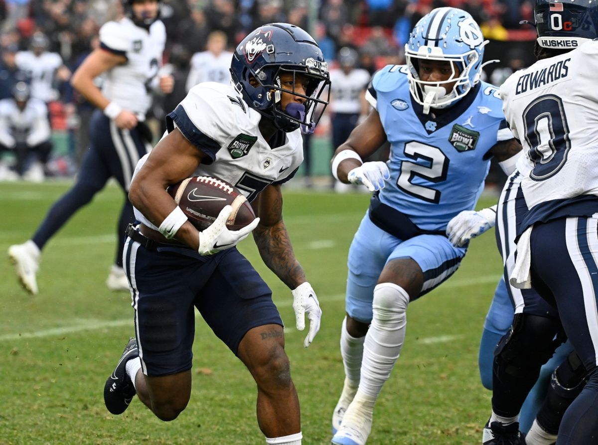 Dec 28, 2024; Boston, MA, USA; Connecticut Huskies running back Mel Brown (7) runs the ball against the North Carolina Tar Heels  during the first half at Fenway Park. Mandatory Credit: Eric Canha-Imagn Images