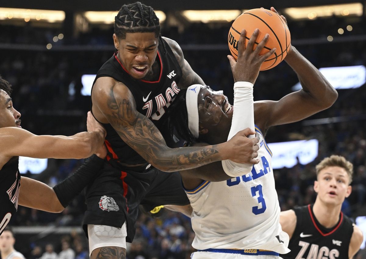 Dec 28, 2024; Inglewood, California, USA; UCLA Bruins guard Eric Dailey Jr. (3) is fouled by Gonzaga Bulldogs guard Khalif Battle (99) during the first half at Intuit Dome. Battle was charged with a flagrant foul on the play. Mandatory Credit: Robert Hanashiro-Imagn Images