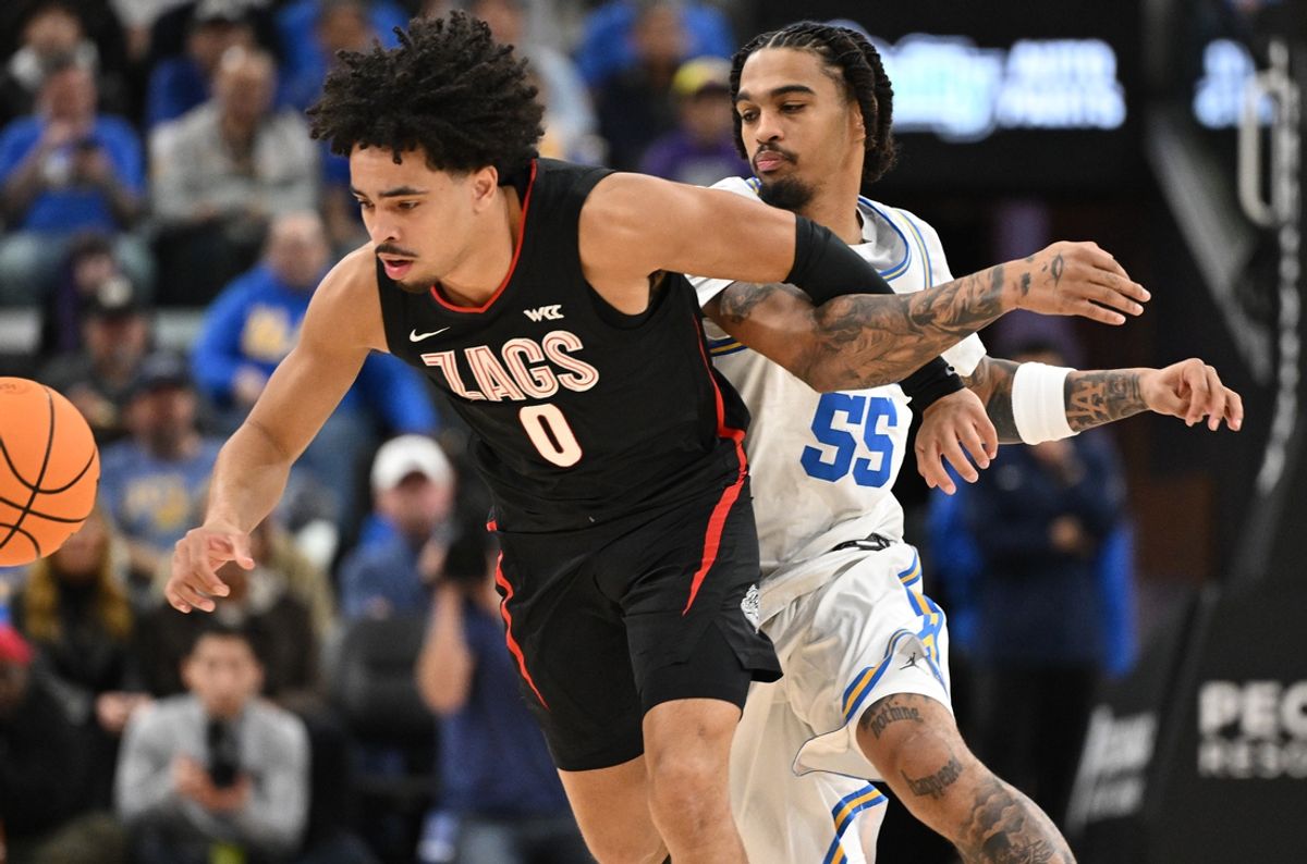 Dec 28, 2024; Inglewood, California, USA; Gonzaga Bulldogs guard Ryan Nembhard (0) and UCLA Bruins guard Skyy Clark (55) chase down a loose bal in the first half at Intuit Dome. Mandatory Credit: Robert Hanashiro-Imagn Images