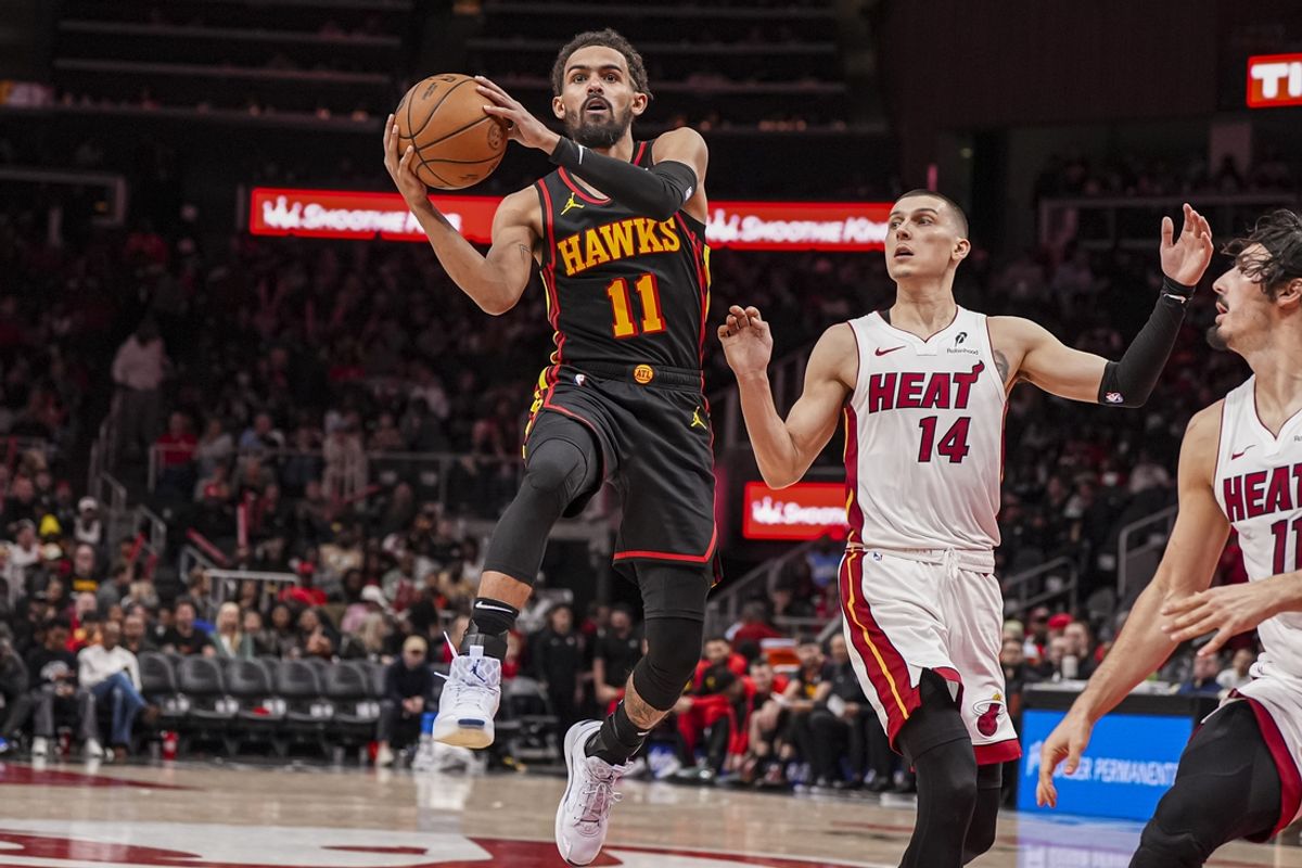 Dec 28, 2024; Atlanta, Georgia, USA; Atlanta Hawks guard Trae Young (11) drives to the basket past Miami Heat guard Tyler Herro (14) at State Farm Arena. Mandatory Credit: Dale Zanine-Imagn Images
