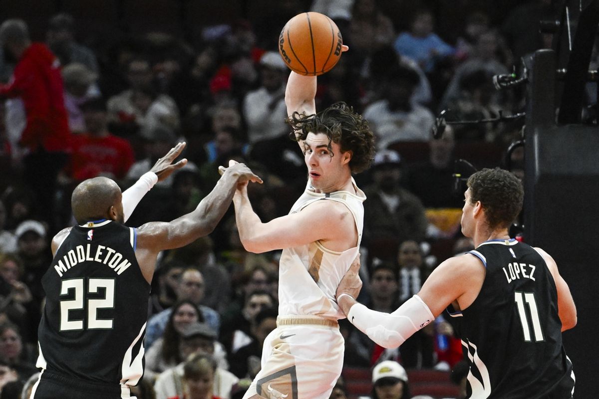 Dec 28, 2024; Chicago, Illinois, USA;  Chicago Bulls guard Josh Giddey (3) passes the ball away from Milwaukee Bucks forward Khris Middleton (22) and  center Brook Lopez (11) during the second half at the United Center. Mandatory Credit: Matt Marton-Imagn Images