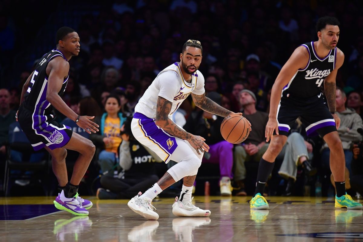 Dec 28, 2024; Los Angeles, California, USA; Los Angeles Lakers guard D'Angelo Russell (1) moves the ball against Sacramento Kings guard De'Aaron Fox (5) during the first half at Crypto.com Arena. Mandatory Credit: Gary A. Vasquez-Imagn Images