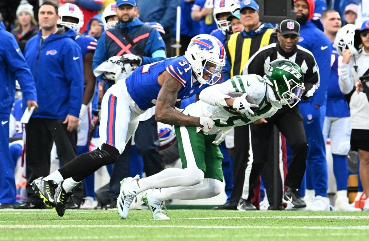 Dec 29, 2024; Orchard Park, New York, USA; New York Jets wide receiver Garrett Wilson (5) is tackled by Buffalo Bills cornerback Rasul Douglas (31) after making a catch in the first quarter at Highmark Stadium. Mandatory Credit: Mark Konezny-Imagn Images
