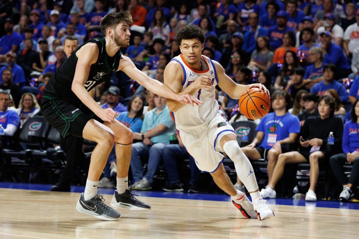 Dec 29, 2024; Gainesville, Florida, USA; Florida Gators guard Walter Clayton Jr. (1) drives to the basket past Stetson Hatters forward Finley Sheridan (21) during the second half at Exactech Arena at the Stephen C. O'Connell Center. Mandatory Credit: Matt Pendleton-Imagn Images