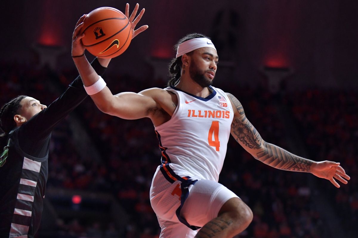 Dec 29, 2024; Champaign, Illinois, USA;  Illinois Fighting Illini guard Kylan Boswell (4) drives past Chicago State Cougars forward Mike Brown (25) and looks to pass during the first half at State Farm Center. Mandatory Credit: Ron Johnson-Imagn Images