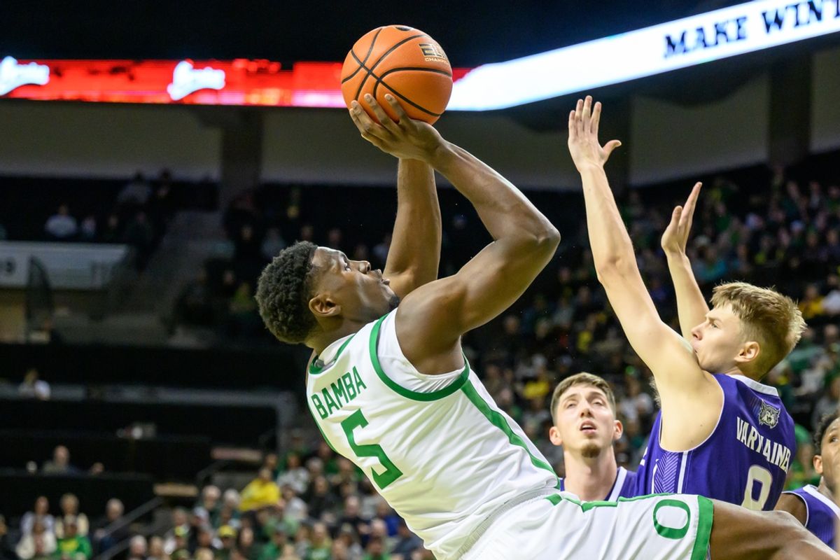 Dec 29, 2024; Eugene, Oregon, USA; Oregon Ducks guard TJ Bamba (5) drives to the basket against Weber State Wildcats guard Viljami Vartiainen (8) during the first half at Matthew Knight Arena. Mandatory Credit: Craig Strobeck-Imagn Images