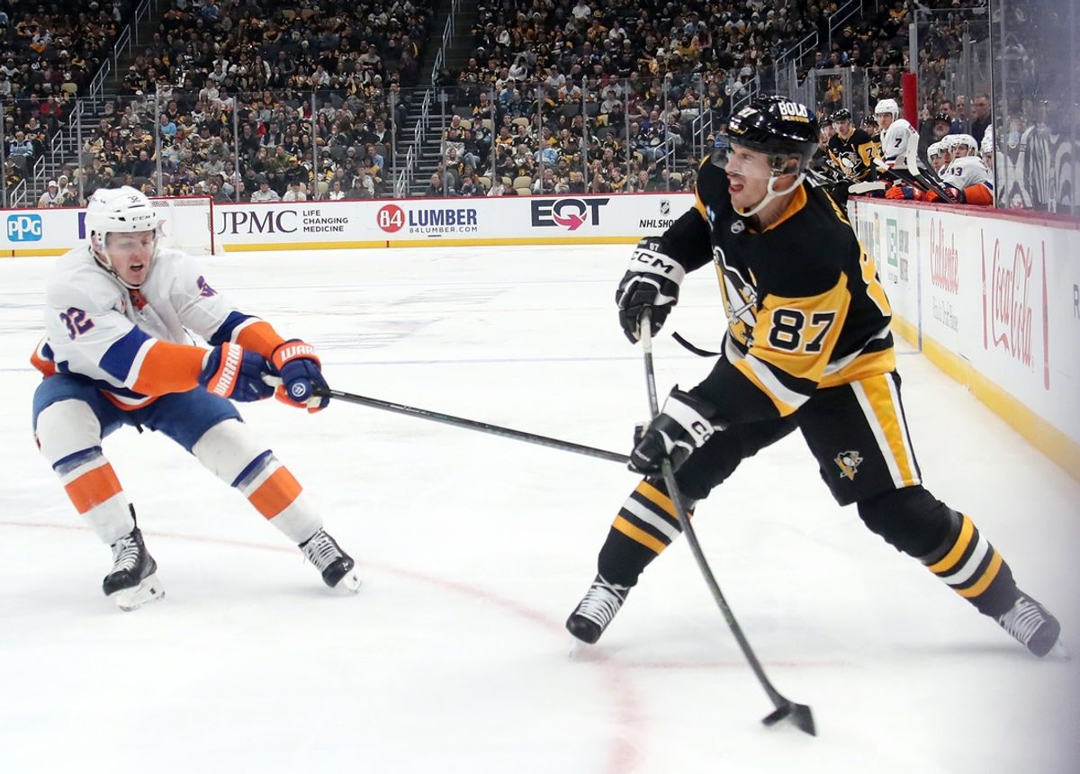 Dec 29, 2024; Pittsburgh, Pennsylvania, USA;  Pittsburgh Penguins center Sidney Crosby (87) shoots the puck against New York Islanders center Kyle MacLean (32)  during the third period at PPG Paints Arena. Mandatory Credit: Charles LeClaire-Imagn Images
