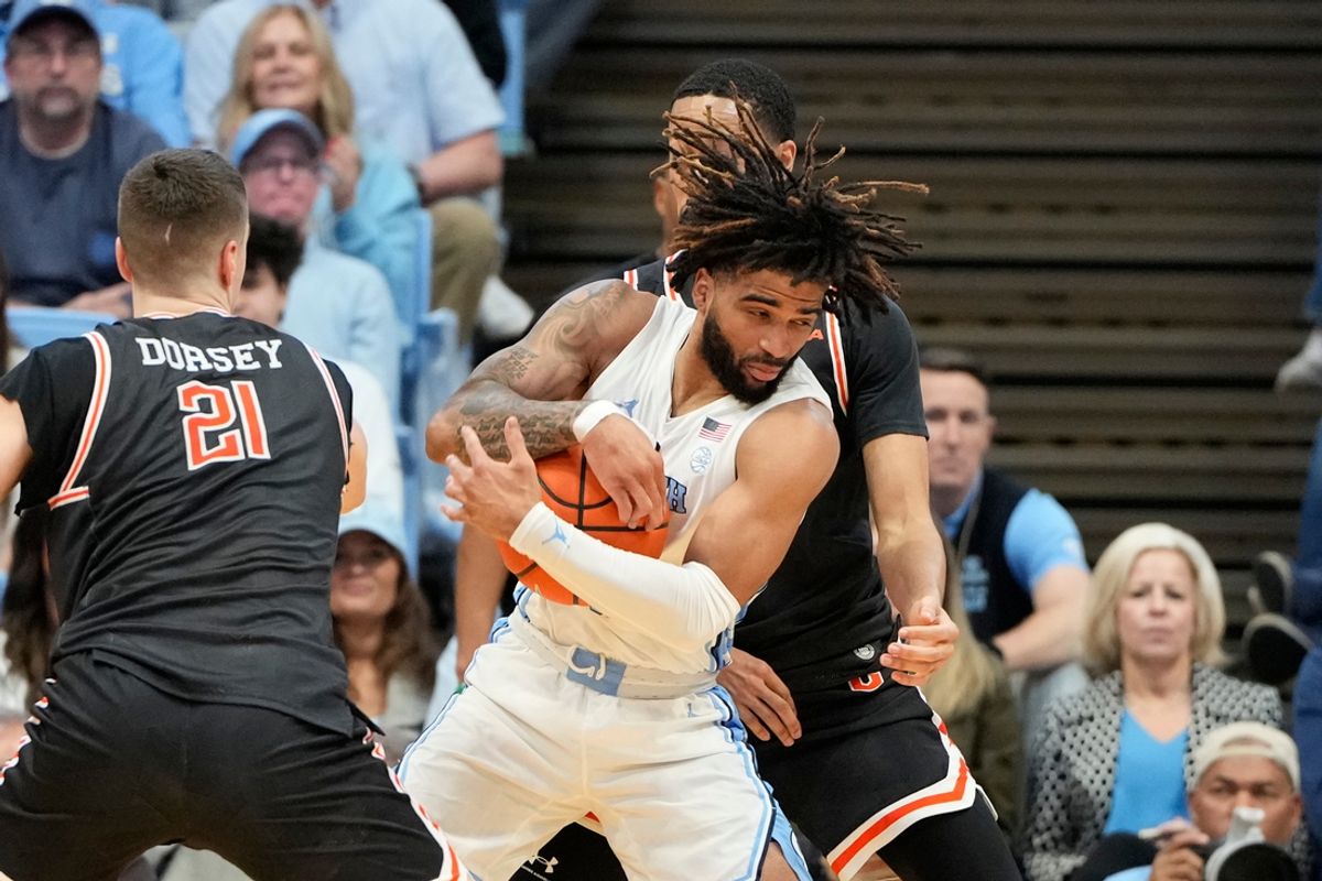Dec 29, 2024; Chapel Hill, North Carolina, USA; North Carolina Tar Heels guard RJ Davis (4) with the ball as Campbell Fighting Camels guard Nolan Dorsey (21) and guard Cam Gregory (7) defend in the first half at Dean E. Smith Center. Mandatory Credit: Bob Donnan-Imagn Images