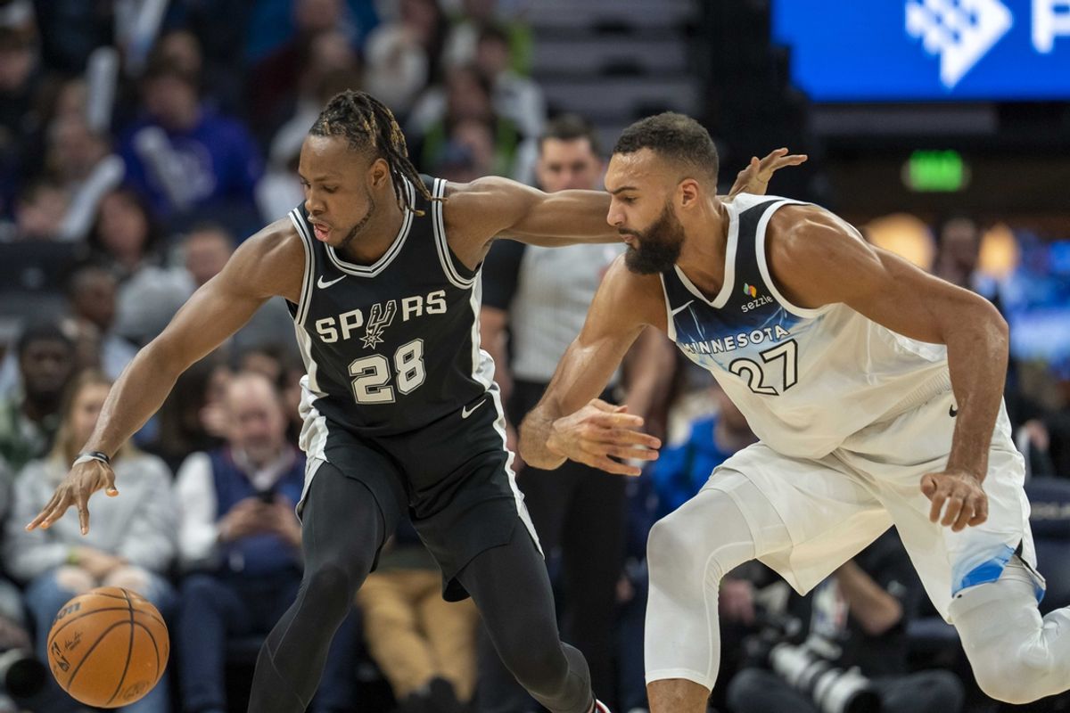 Dec 29, 2024; Minneapolis, Minnesota, USA; San Antonio Spurs center Charles Bassey (28) and Minnesota Timberwolves center Rudy Gobert (27) fight for a loose ball in the first half at Target Center. Mandatory Credit: Jesse Johnson-Imagn Images