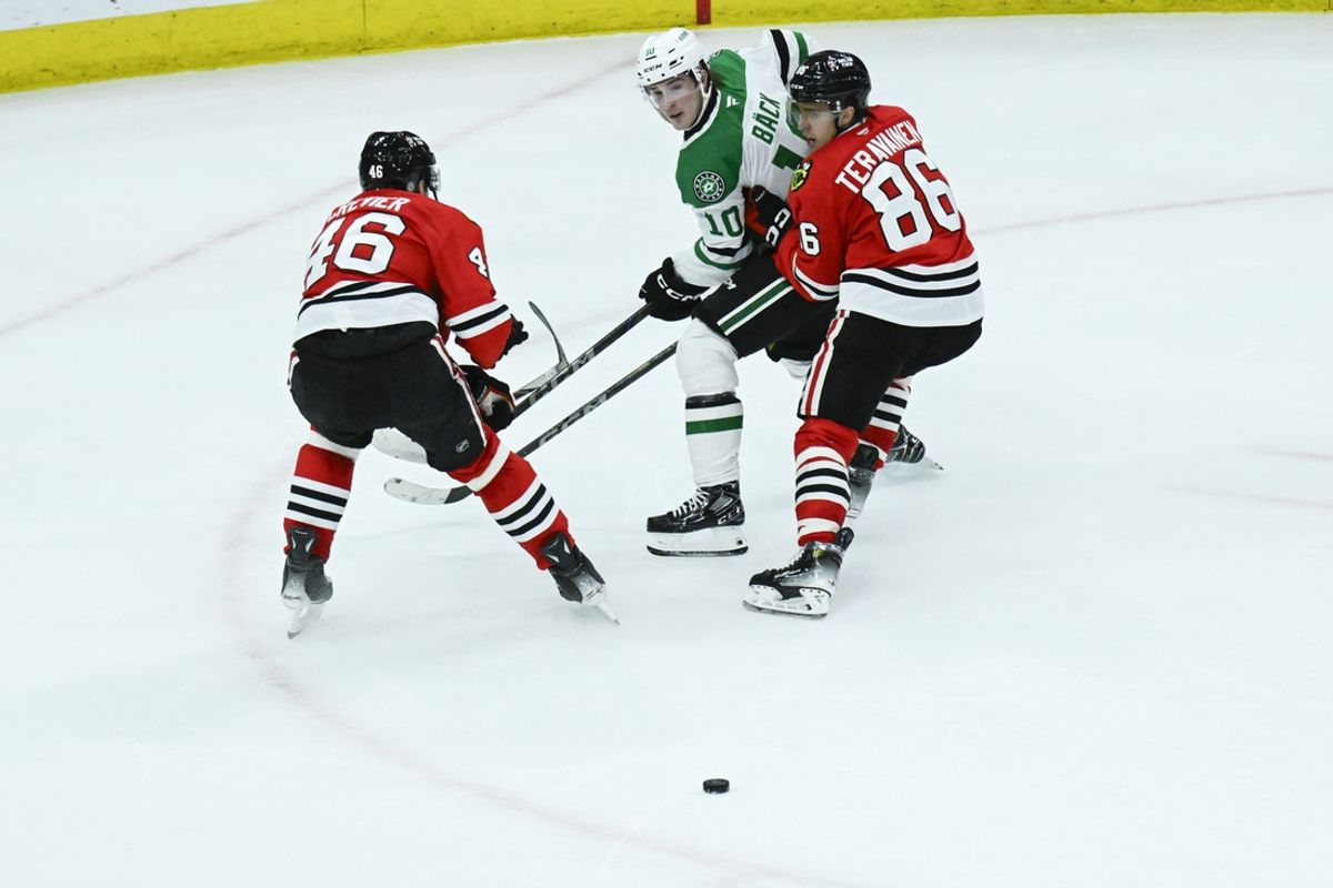 Dec 29, 2024; Chicago, Illinois, USA;  Dallas Stars center Oskar Bäck (10) moves the puck past Chicago Blackhawks defenseman Louis Crevier (46) and center Teuvo Teravainen (86) during the second period at United Center. Mandatory Credit: Matt Marton-Imagn Images