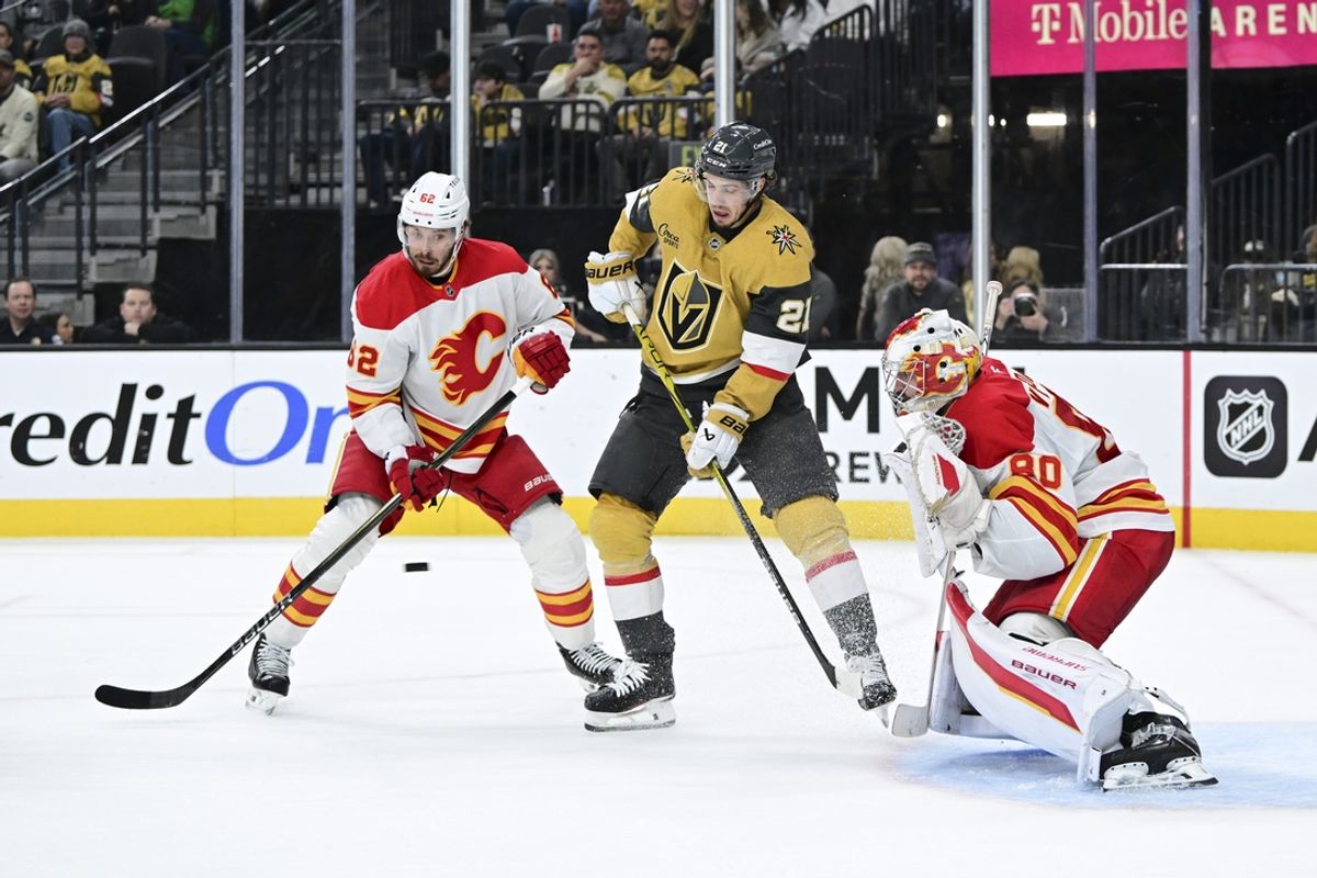 Dec 29, 2024; Las Vegas, Nevada, USA; Vegas Golden Knights center Brett Howden (21) looks to shoot the puck against Calgary Flames defenseman Daniil Miromanov (62) and Calgary Flames goaltender Dan Vladar (80) in the second period of the game at T-Mobile Arena. Mandatory Credit: Candice Ward-Imagn Images
