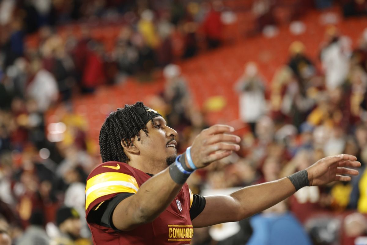 Dec 29, 2024; Landover, Maryland, USA; Washington Commanders quarterback Jayden Daniels (5) celebrates with fans in the stands while leaving the field after defeating the Atlanta Falcons at Northwest Stadium. Mandatory Credit: Amber Searls-Imagn Images