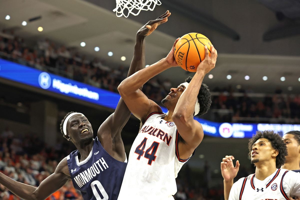 Dec 30, 2024; Auburn, Alabama, USA; Monmouth Hawks center Dok Muordar (0) tries to block the shot of Auburn Tigers center Dylan Cardwell (44) during the second half at Neville Arena. Mandatory Credit: John Reed-Imagn Images