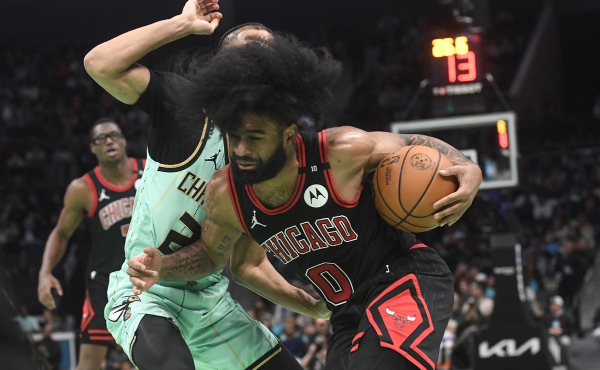 Dec 30, 2024; Charlotte, North Carolina, USA;  Chicago Bulls guard Coby White (0) drives past Charlotte Hornets guard Isaiah Wong (21) during the second half at the Spectrum Center. Mandatory Credit: Sam Sharpe-Imagn Images