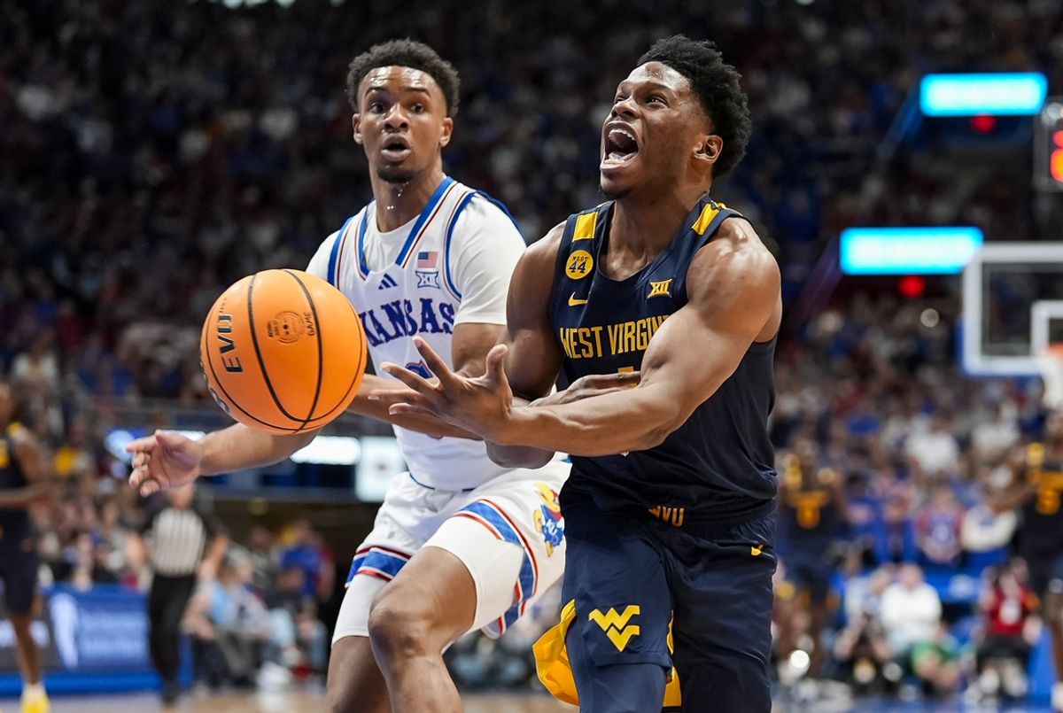 Dec 31, 2024; Lawrence, Kansas, USA; West Virginia Mountaineers guard Joseph Yesufu (1) loses the ball while driving against Kansas Jayhawks guard Rylan Griffen (6) during the first half at Allen Fieldhouse. Mandatory Credit: Jay Biggerstaff-Imagn Images