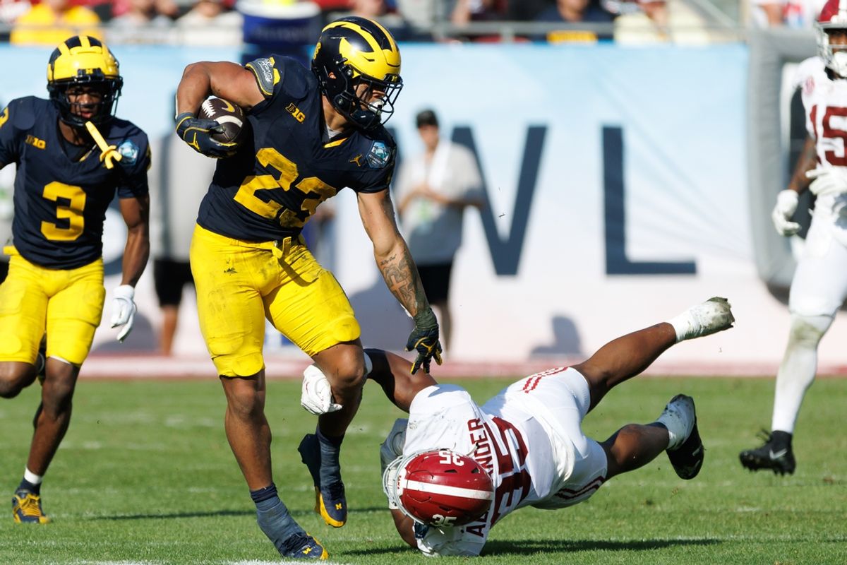 Dec 31, 2024; Tampa, FL, USA; Michigan Wolverines running back Jordan Marshall (23) pushes off on Alabama Crimson Tide linebacker Jeremiah Alexander (35) during the second half at Raymond James Stadium. Mandatory Credit: Matt Pendleton-Imagn Images
